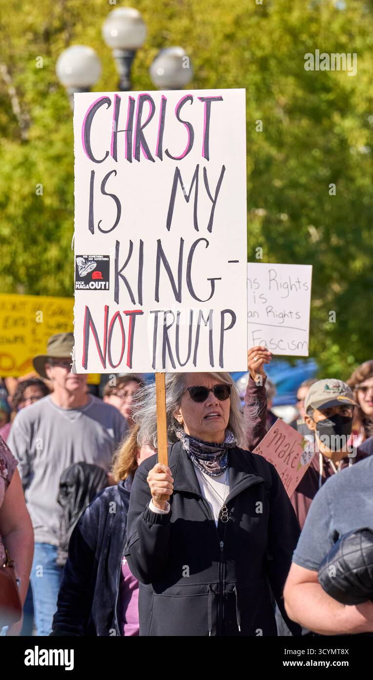 Eine Frau hält ein Schild, während sie am 18. Oktober 2025 in Eugene, Oregon, bei einer No Kings Demonstration marschiert. Stockfoto