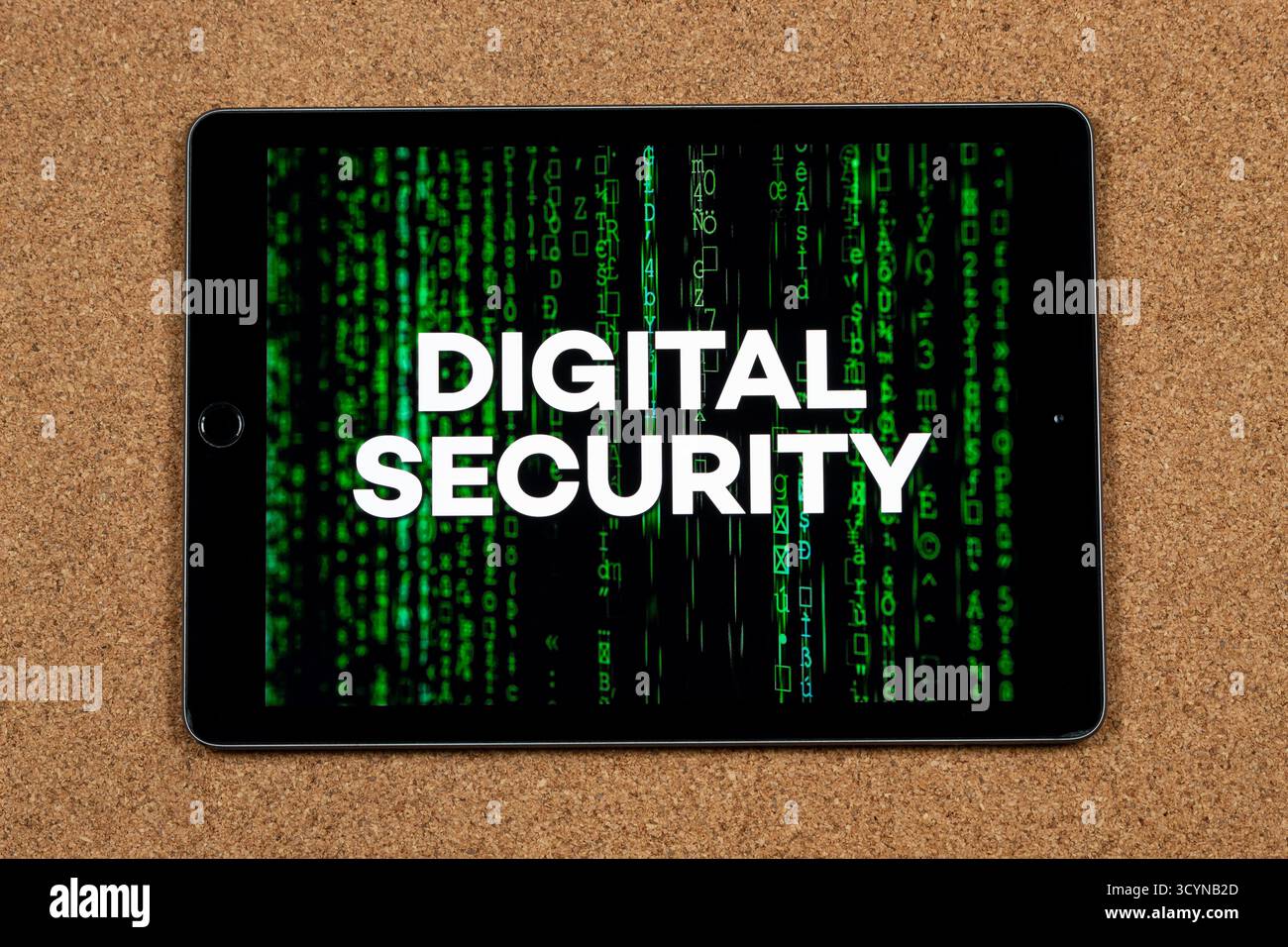 Nahaufnahme eines Tablets mit dem Satz digitale Sicherheit über einem grünen Matrix-Code-Konzept und einem Korkhintergrund Stockfoto