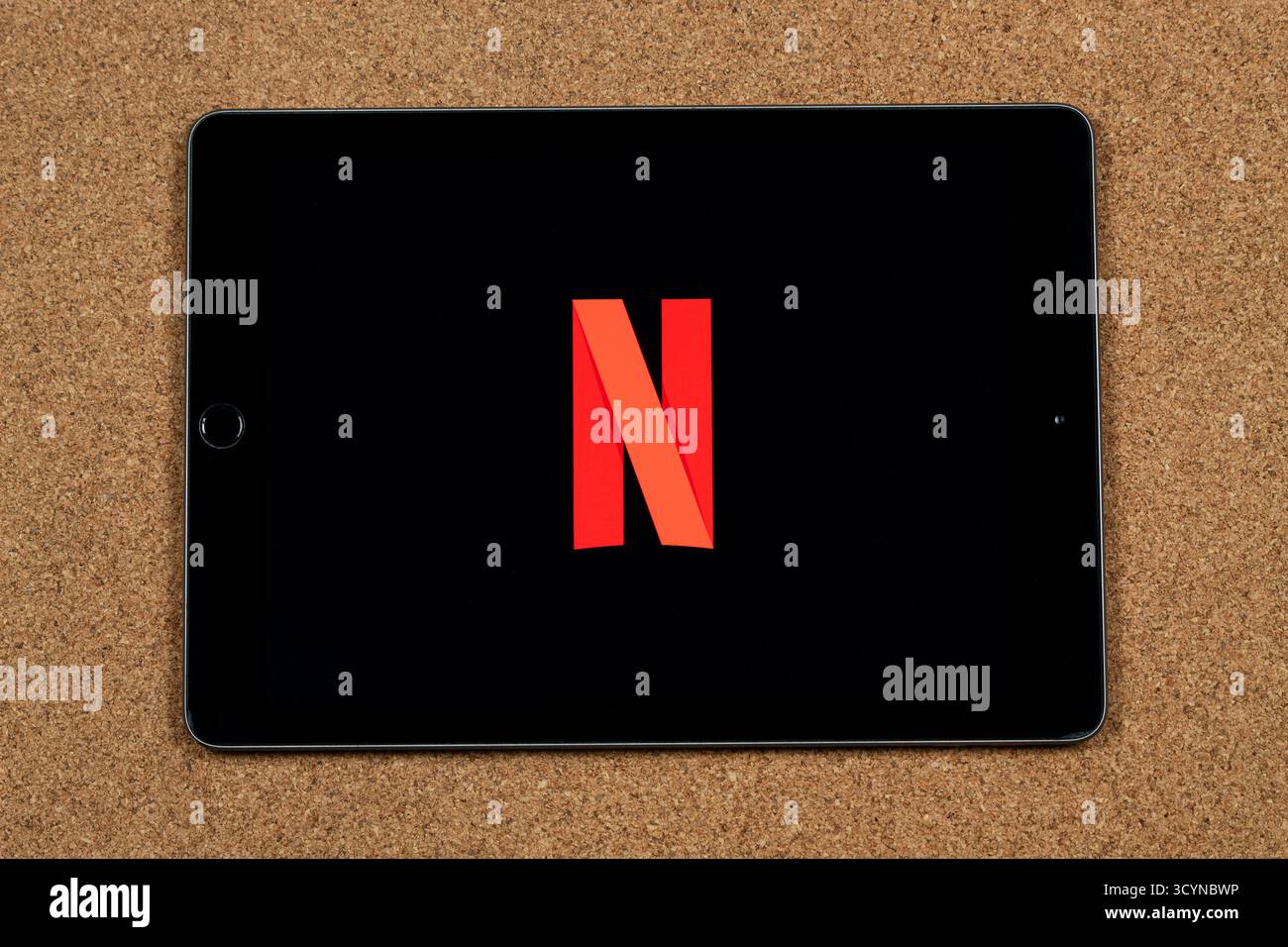 Nahaufnahme eines iPad mit dem roten N-Symbol des Netflix-Streaming-Dienstes auf schwarzem Hintergrund und Korkhintergrund Stockfoto