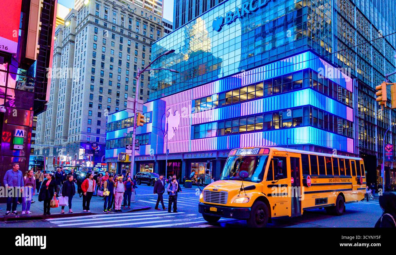 New York, USA, Times Square Evening Glow mit gelbem Schulbus und LED-Reflektionen Stockfoto