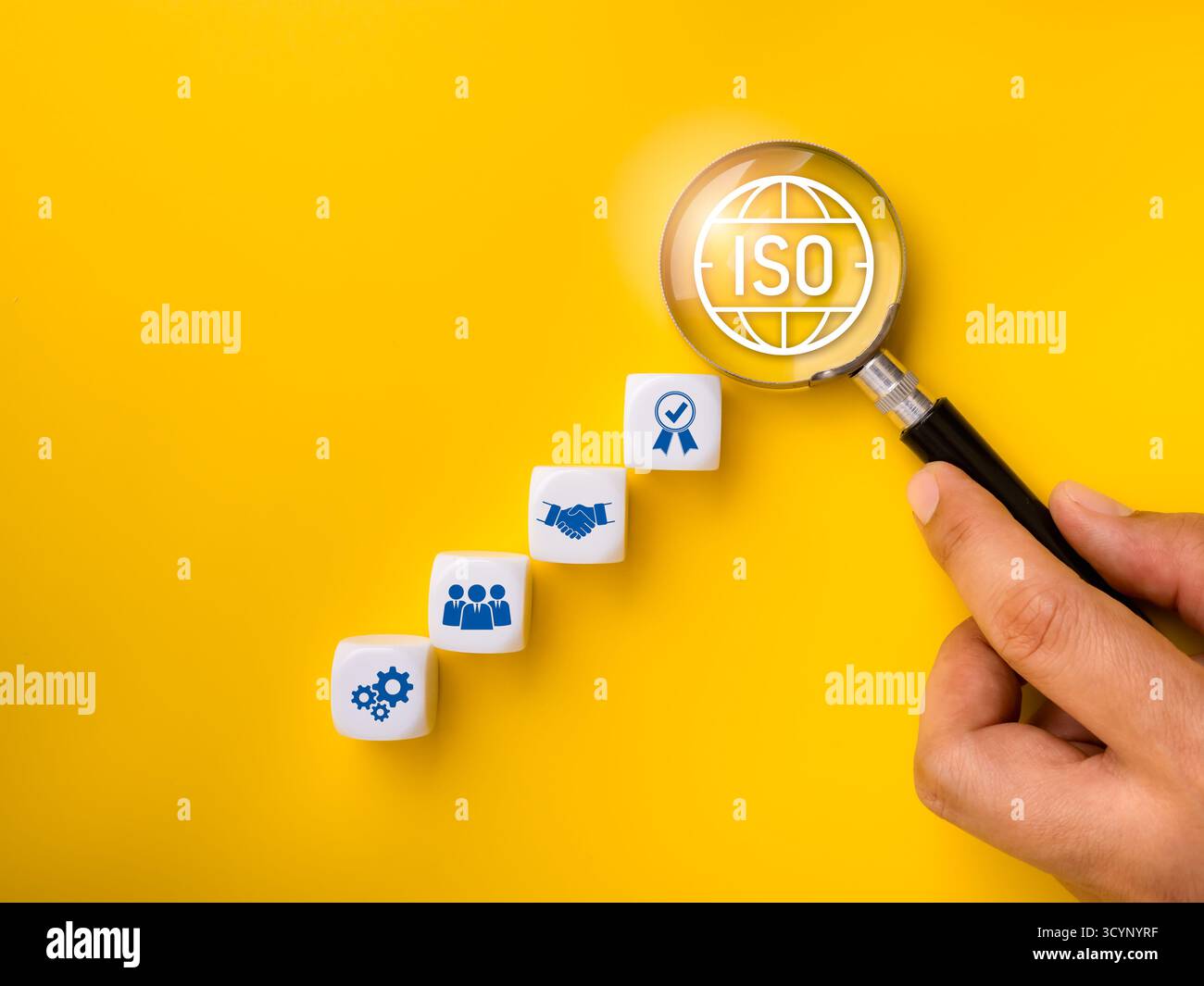 ISO-Zertifizierung und Qualitätsmanagementkonzept mit Lupe, die ISO-Symbole und Prozesssymbole auf Würfeln hervorhebt. Steht für Standardisierung, Stockfoto