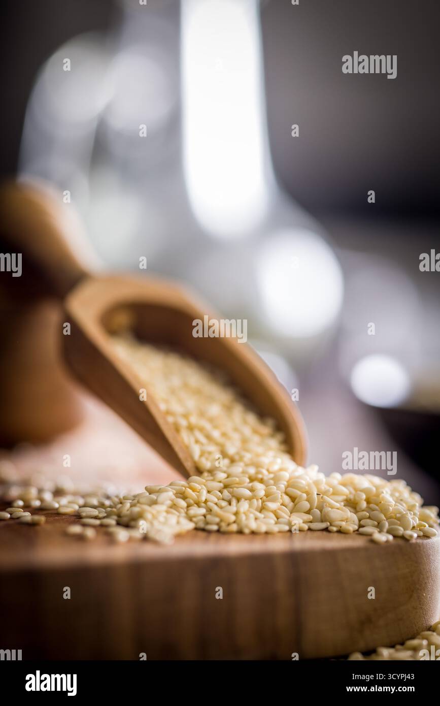 Gebratene Sesamsamen in einer Schaufel auf einem Holztisch. Stockfoto