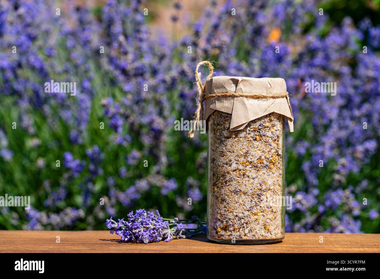 Himalaya-Meersalz mit trockenem Lavendel und Kamillenblüten im Glas der Lavendelblüten Hintergrund auf Holztisch an sonnigen Sommertagen. Natürlich b Stockfoto