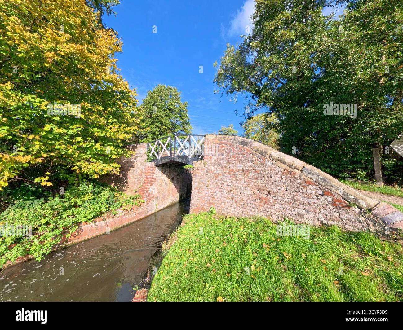 Blick auf die englische ländliche Landschaft auf dem britischen Wasserstraßenkanal mit alter traditioneller Steinbrücke Stockfoto
