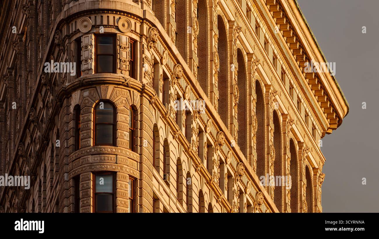 Detaillierte Sicht auf die Fassade des Flatiron Building bei Sonnenuntergang. Beaux-Arts-Architektur mit komplizierten Terrakotta-Ornamenten. Manhattan, New York City Stockfoto