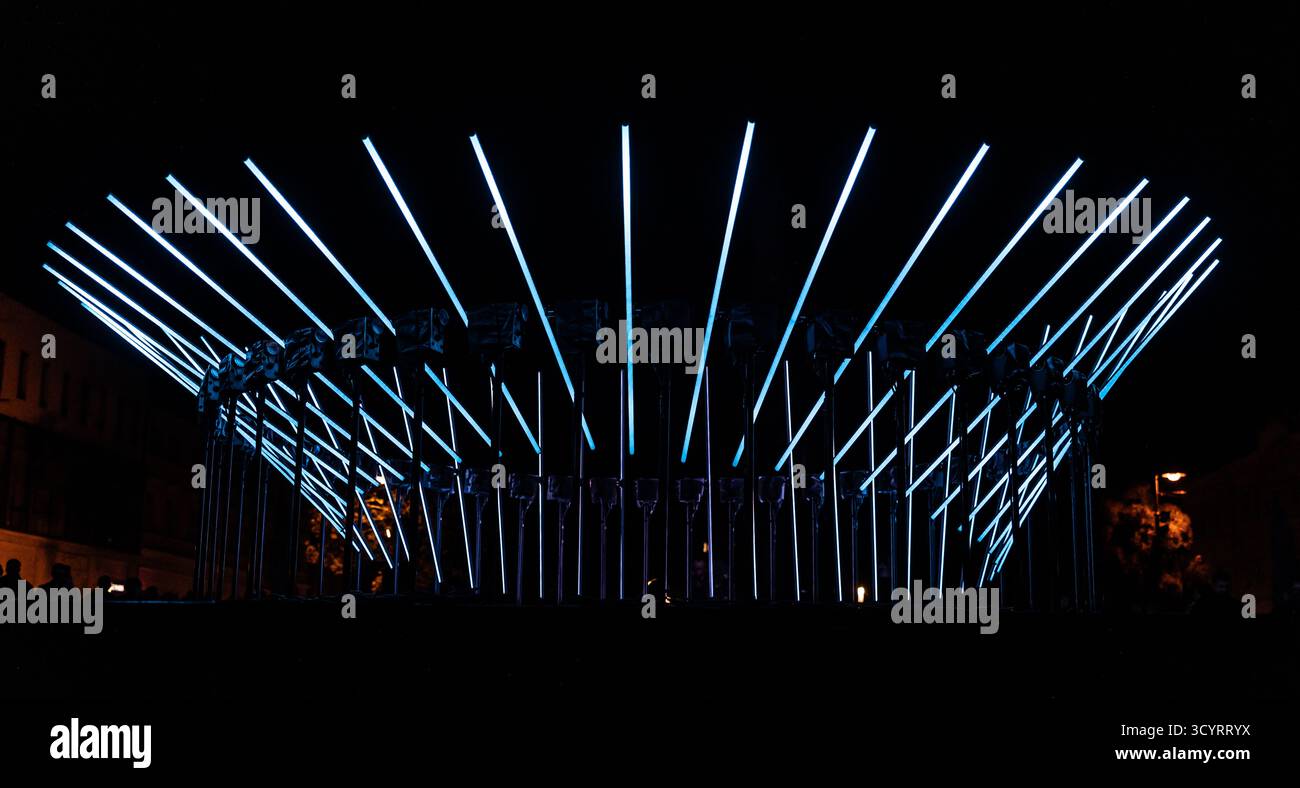 Die faszinierende Nachtszene fängt eine moderne Lichtinstallation ein, die den Raum mit einer futuristischen Ästhetik dominiert und aus einer Reihe von Diag besteht Stockfoto