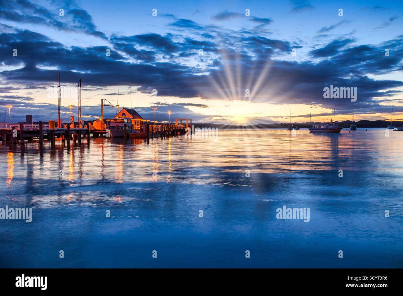 Russell, Bay of Islands, Neuseeland, bei Sonnenuntergang. Der Steg leuchtet, wenn die Sonne untergeht. Stockfoto
