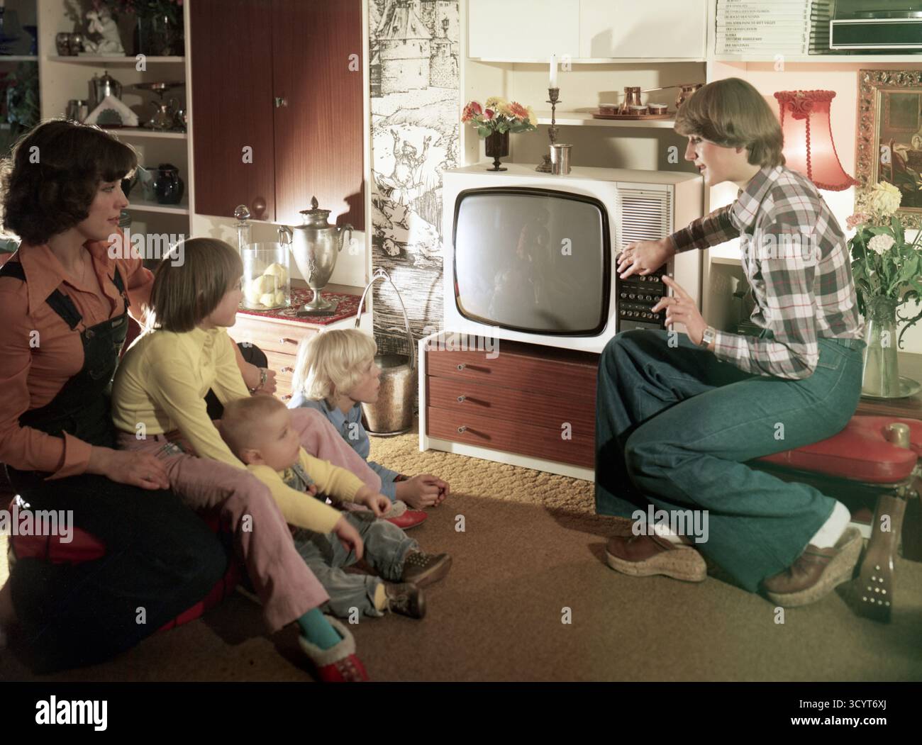 29.10.1976, Deutsche Demokratische Republik, Berlin - Frauen schauen mit ihren Kindern fern. Werbespot für das Fernsehgerät Chromat 1060 Stockfoto