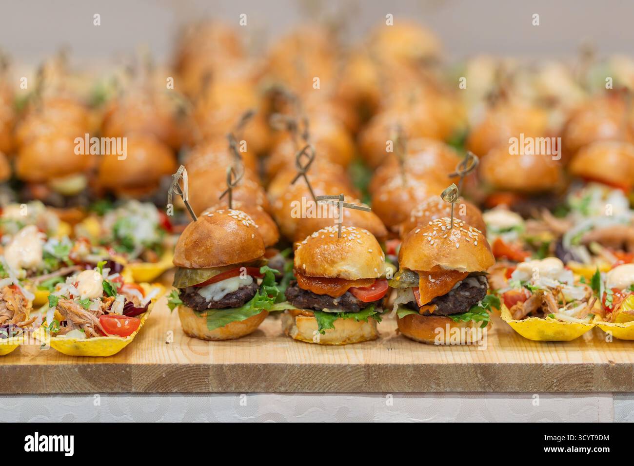 Leckere Snacks am Catering-Buffet für Business-Events. Kaffeepause, Catering für Geschäftstreffen. Mini-Burger und Fleischsalatbecher für Geschäftsleute und Businessleute Stockfoto