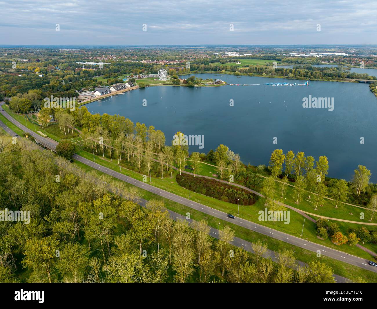Wille Lake, Milton Keynes, Buckinghamshire, England. Die Szene zeigt den See mit umliegenden Parkflächen und Bäumen Stockfoto