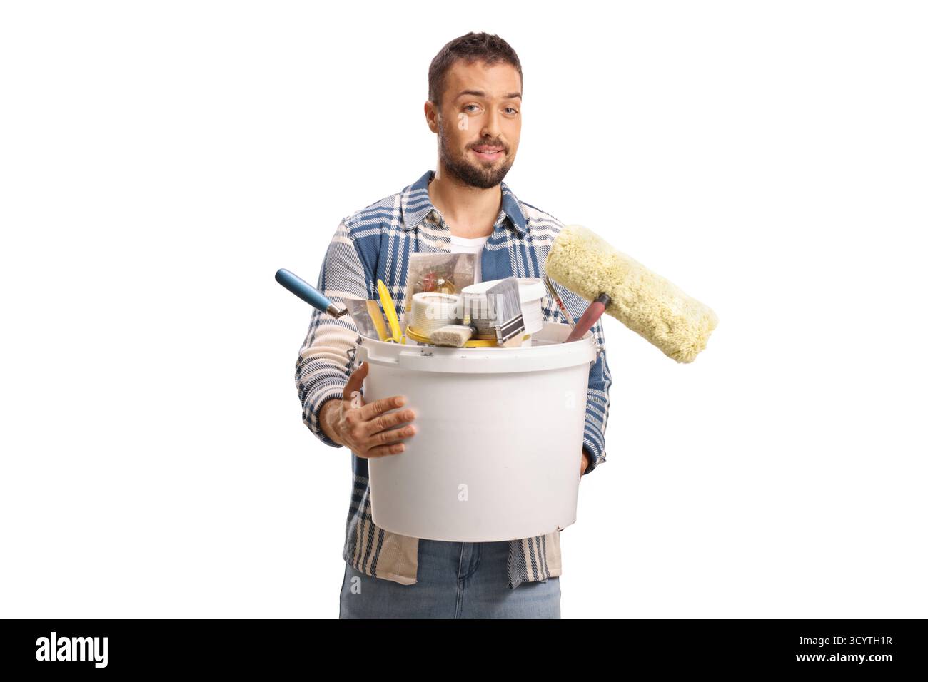 Junger Mann, der einen Eimer mit Werkzeugen zum Malen auf weißem Hintergrund hält Stockfoto