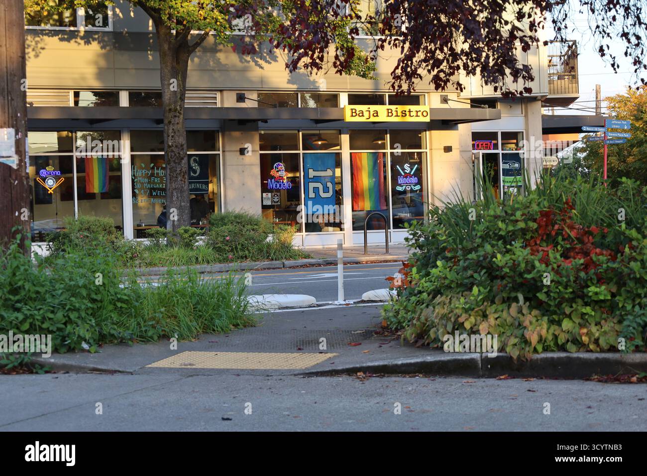Baja Bistro auf der Beacon Avenue South, Seattle, WA, fotografiert im Herbstabendlicht am 17. Oktober 2025. Modernes Äußere, Regenbogenflagge, Neonschilder. Stockfoto