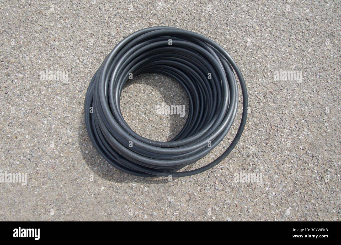 PE-Rohr für landwirtschaftliche Zwecke auf dem Boden. Gartengeräte zur Tropfbewässerung Stockfoto