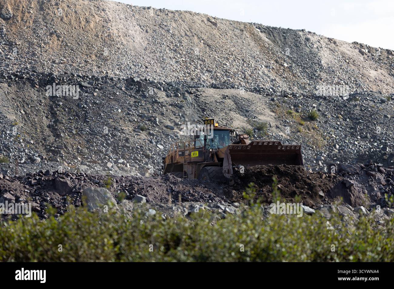 Bergeflächen und Gesteinsschichten aus der Eisenmine Fire Lake erheben sich über den dichten Wald und das reflektierende Wasser des nördlichen Québec. Stockfoto