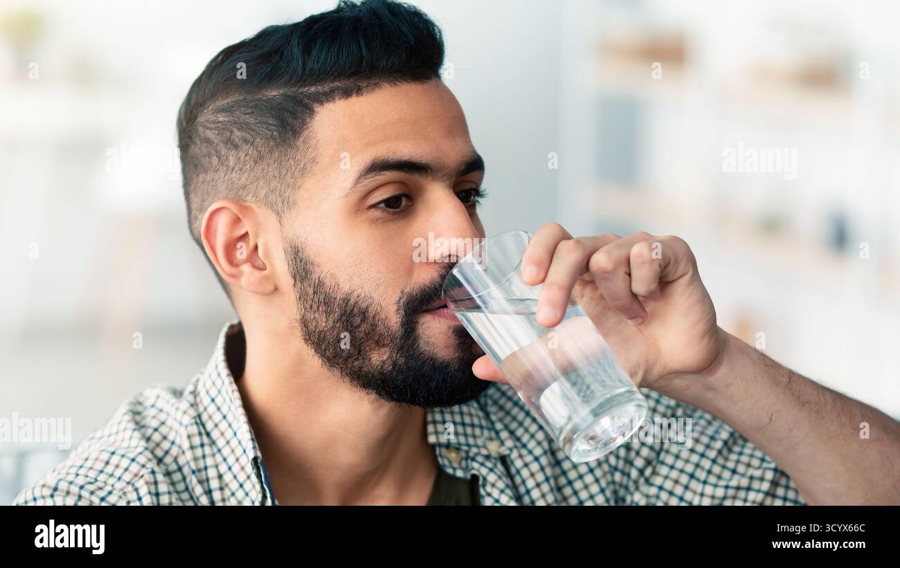 Mann genießt tagsüber drinnen ein erfrischendes Getränk Stockfoto
