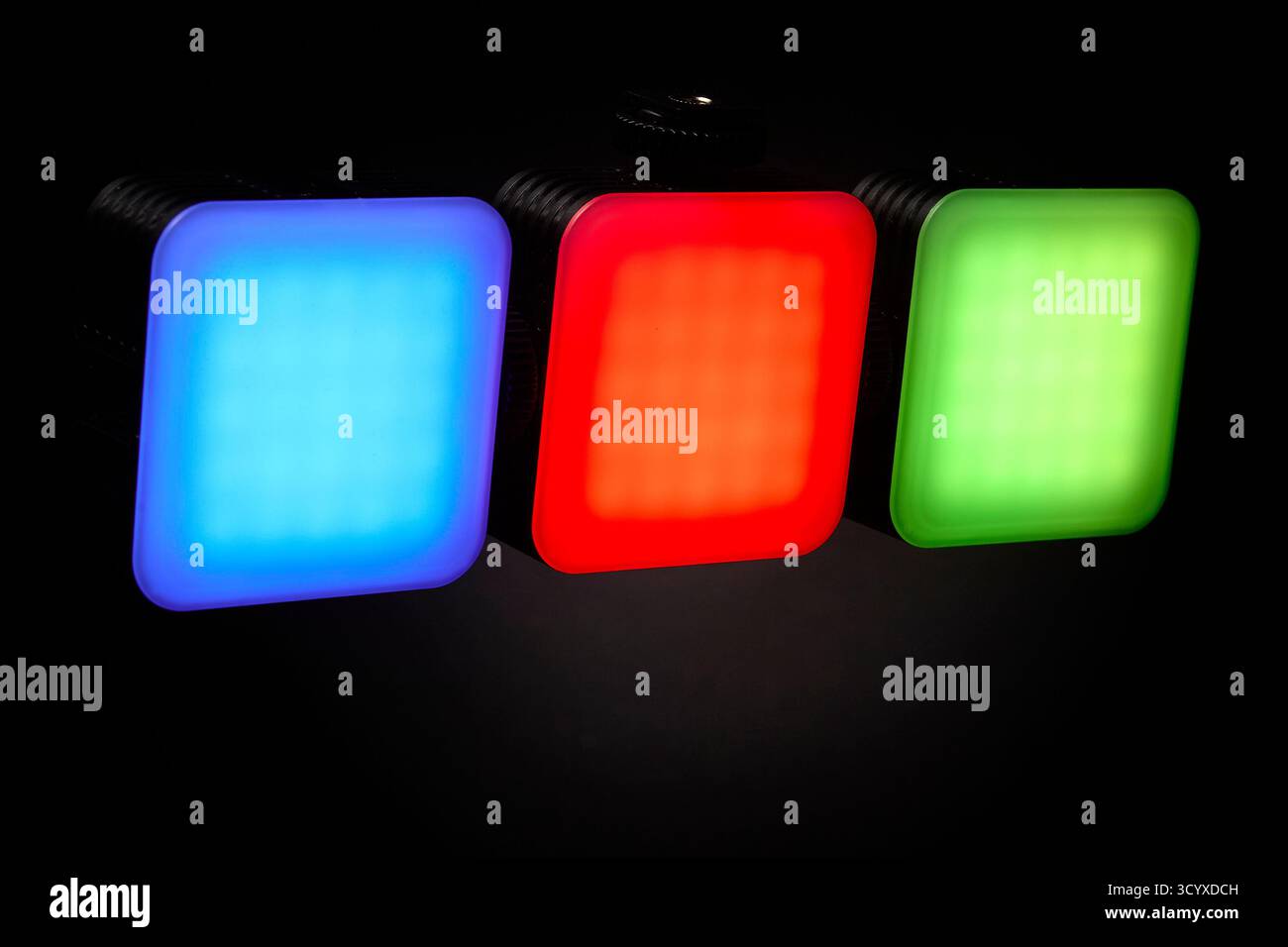 Drei RGB-LED-Panels leuchten in leuchtenden Rot-, Blau- und Grüntönen auf schwarzem Hintergrund. Studio-Konzept für Farbbalance und professionelle Beleuchtung Stockfoto