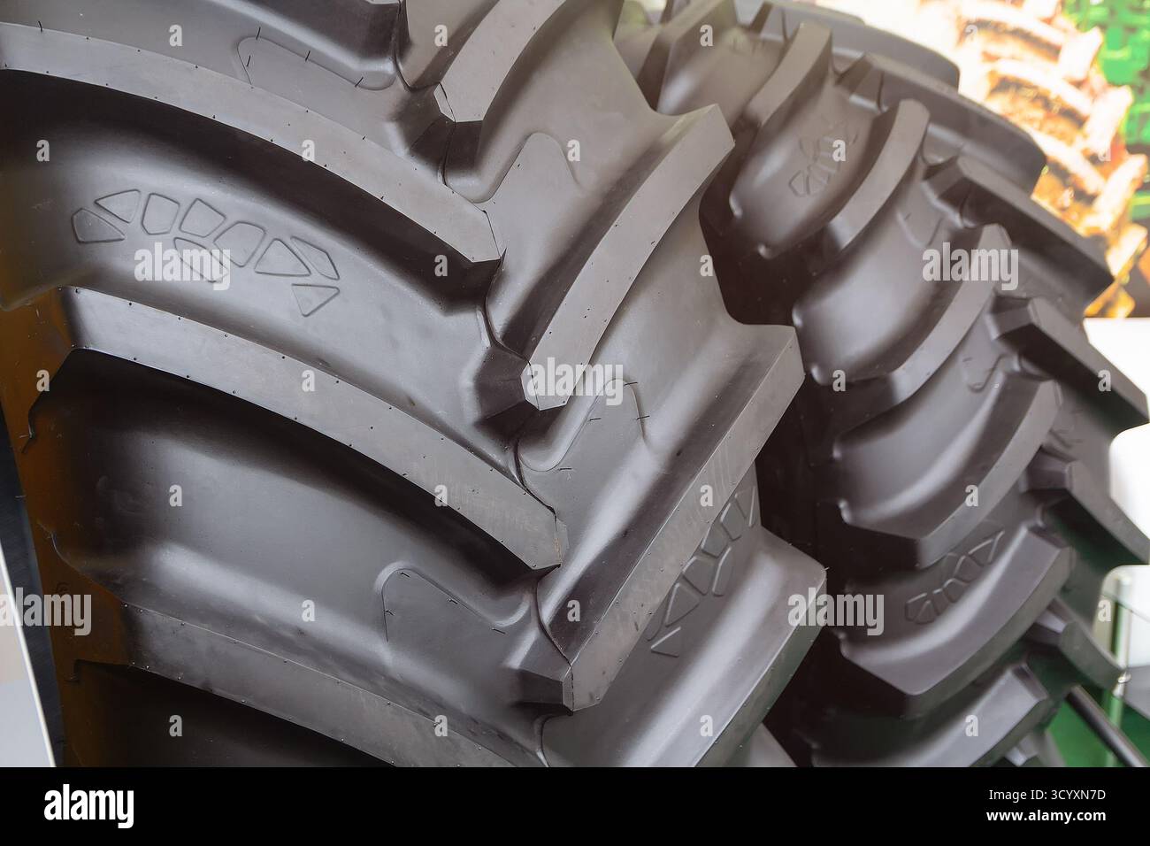 Neue Traktorreifen mit großem Profil in der Nahaufnahme des Ausstellungsraums. Industrie Stockfoto