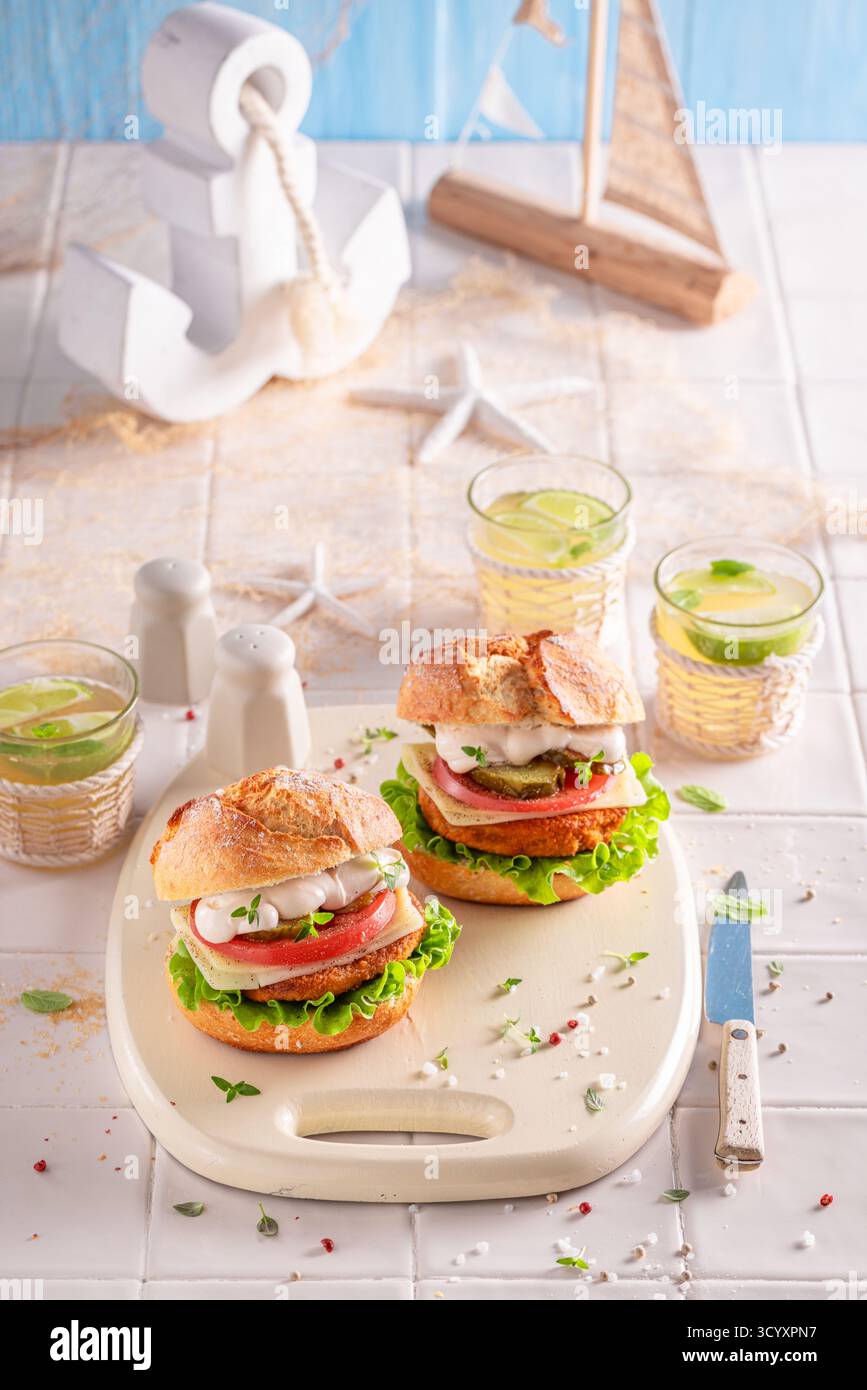Gesunder Fischburger mit Tomaten, Salat und Käse. Fischburger mit Gemüse und Fisch. Stockfoto