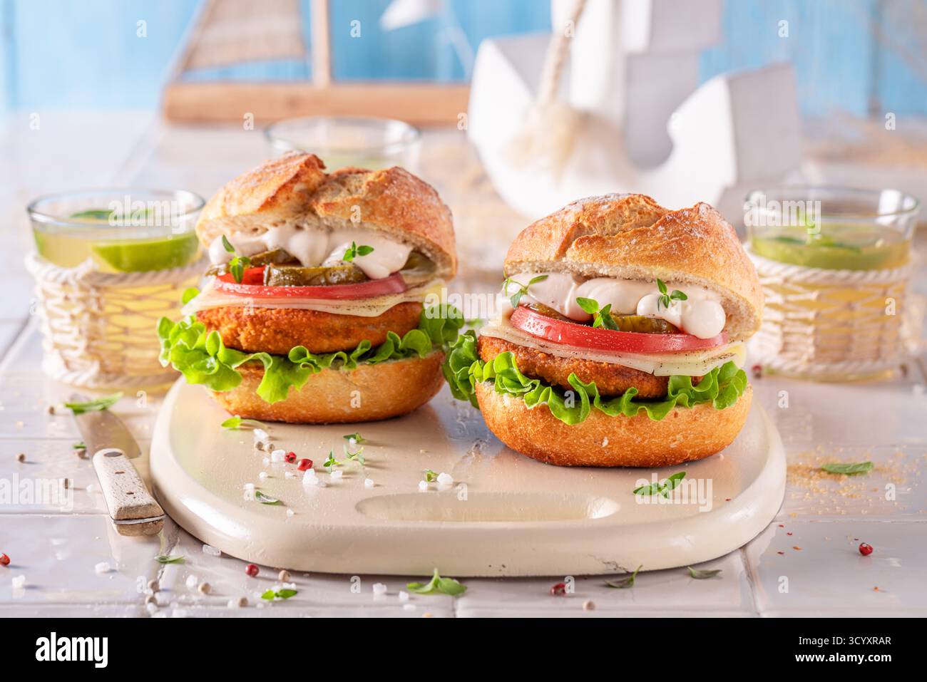 Fischburger mit Tomaten, Salat und Käse. Fischburger mit Gemüse und Fisch. Stockfoto