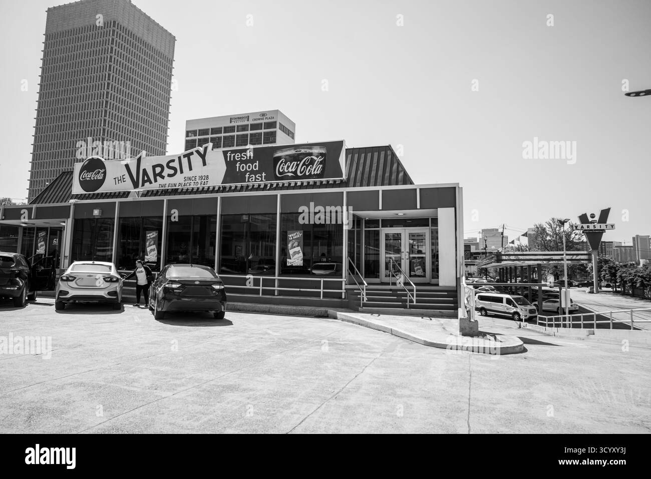 Vor dem Varsity, dem legendären Fast-Food-Restaurant in der Innenstadt von Atlanta, Georgia, steigen und verlassen die Menschen in Schwarz-weiß Stockfoto