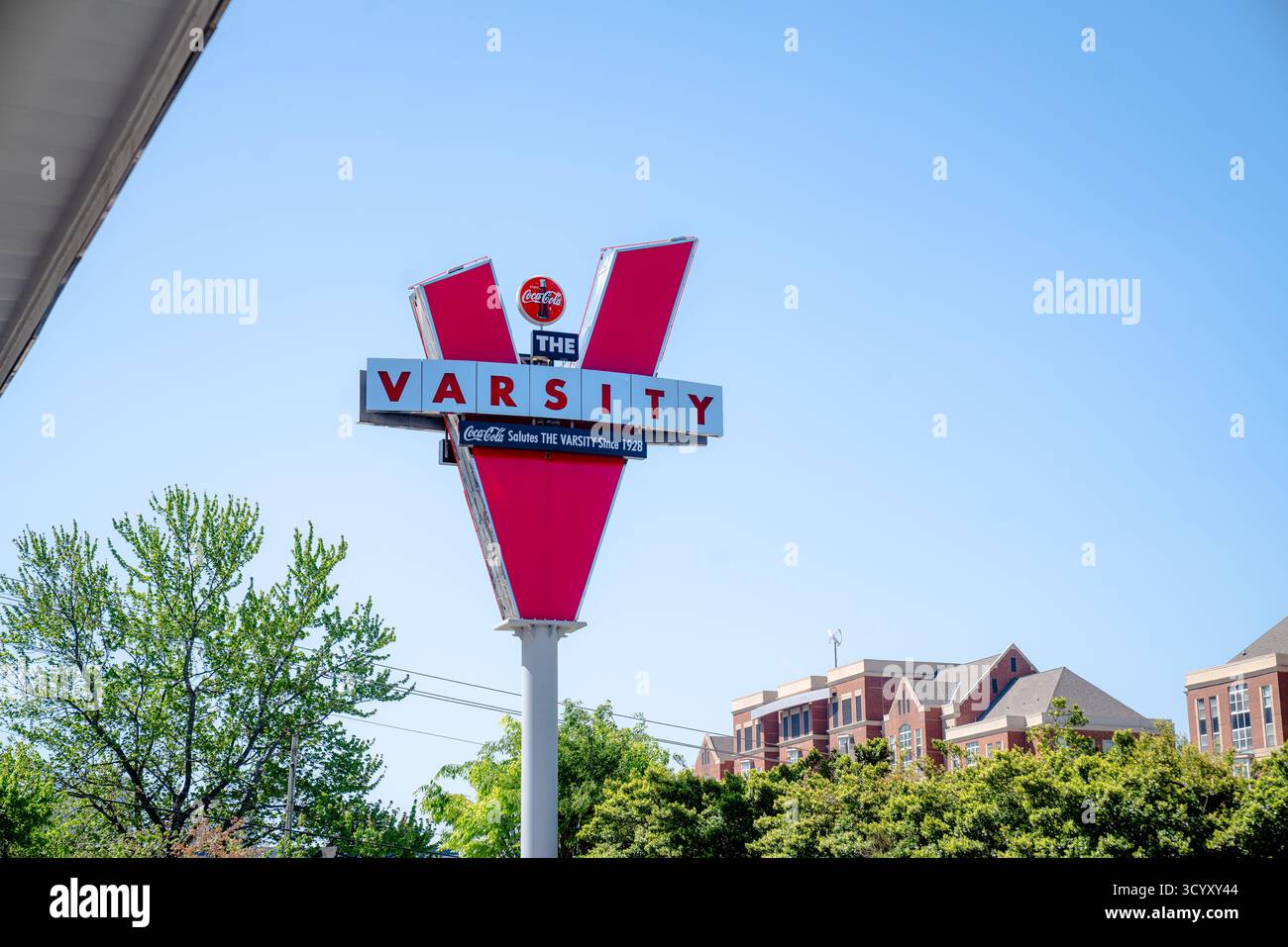 Das legendäre rote „V“-Schild für das Varsity, ein historisches Autokino, das 1928 gegründet wurde, steht vor einem klaren blauen Himmel in der Nähe des Campus von Georgia Tech Stockfoto