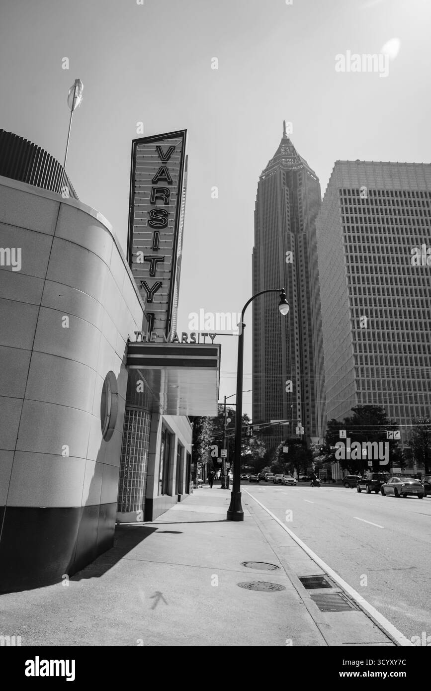 Das ikonische rote Neonschild des Varsity leuchtet unter einem klaren blauen Himmel, hinter dem sich die Bank of America Plaza erhebt Stockfoto