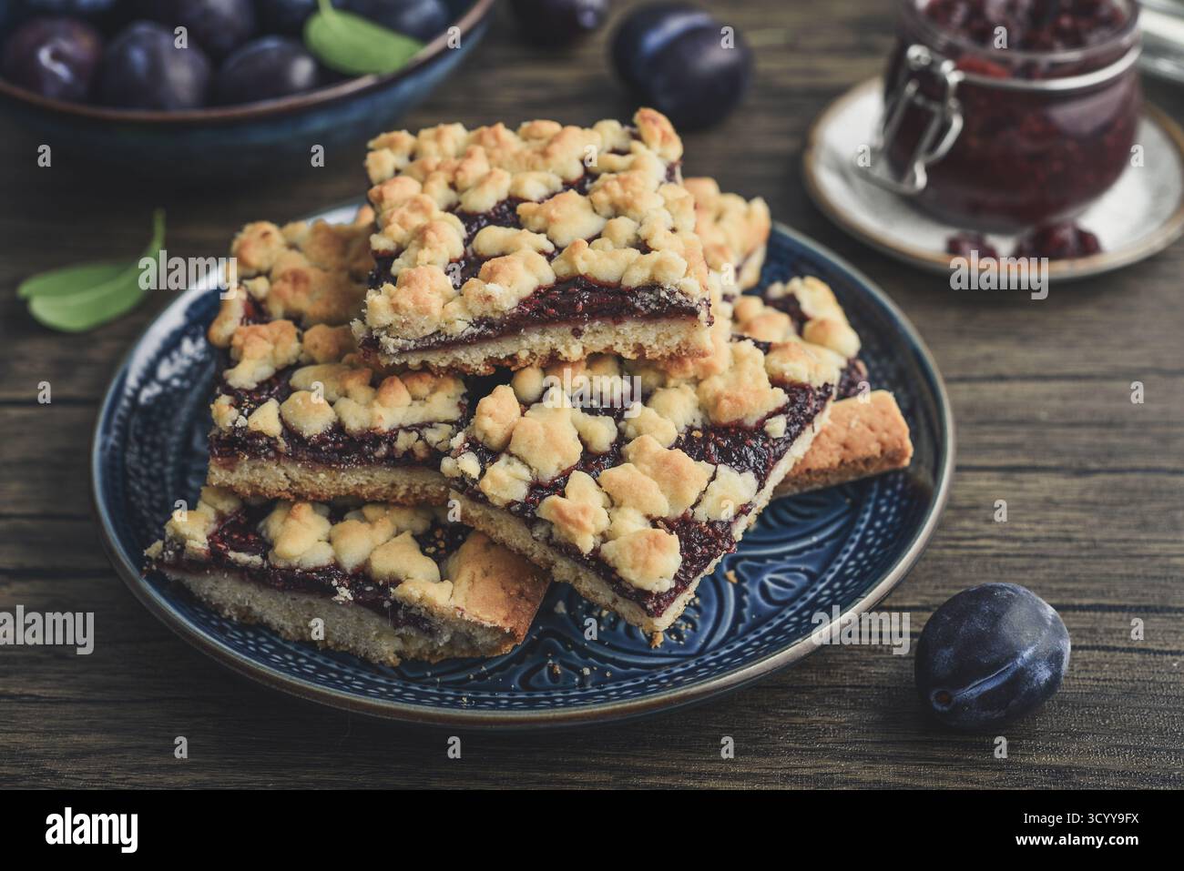 Traditioneller deutscher Zwetschgenkuchen auf blauem Teller mit Pflaumenscheiben und Pflaumenmarmelade, Nahaufnahme Stockfoto