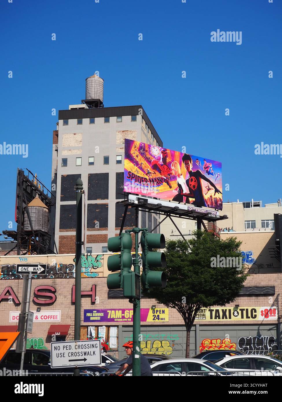Spider-man über die Spider-Vers-Werbetafel an einem sonnigen Tag in New York City mit blauem Himmel und Wasserturm Stockfoto