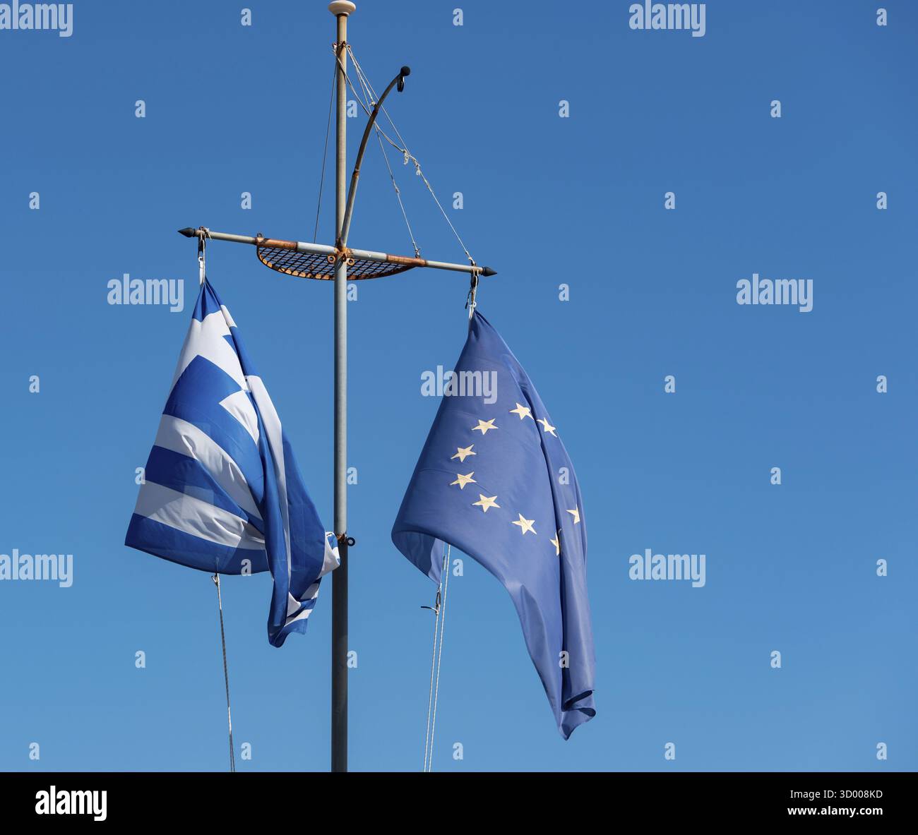 Griechische Flagge und Europaflagge vor blauem Himmel griechische Flagge und Europaflagge vor blauem Himmel Stockfoto