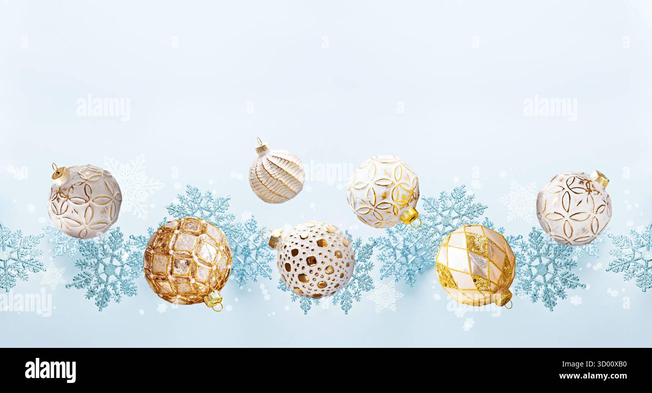 Goldene und weiße Ornamente mit blauen Schneeflocken auf hellem Hintergrund Stockfoto