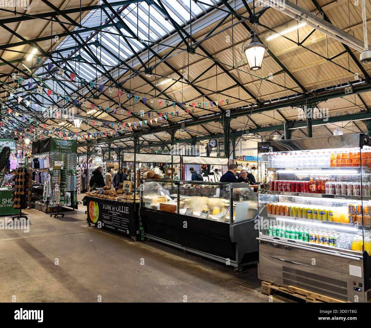 Belfast Indoor Market mit verschiedenen Speise- und Getränkeständen unter einem hohen Glasdach mit Einkaufsmöglichkeiten und farbenfroher Dekoration Stockfoto