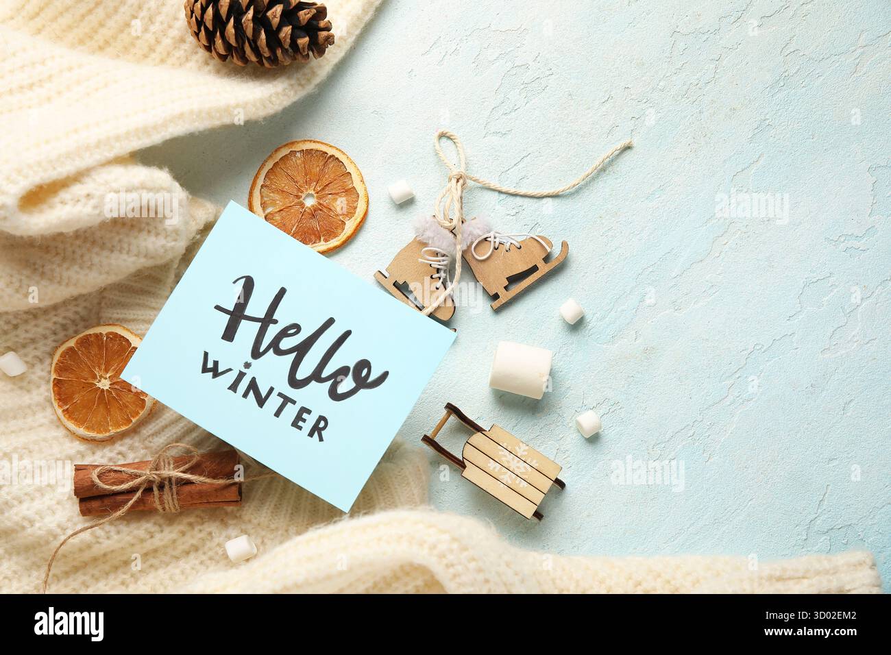 Papier mit Text HALLO WINTER, Leckereien, Weihnachtsspielzeug und Pullover auf Grunge Hintergrund Stockfoto
