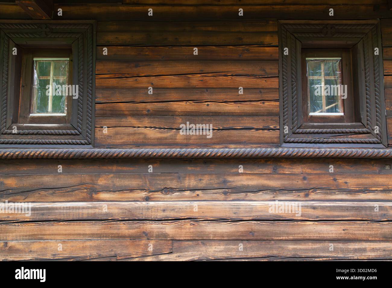 Fassade eines alten Holzhauses mit Fenstern Stockfoto