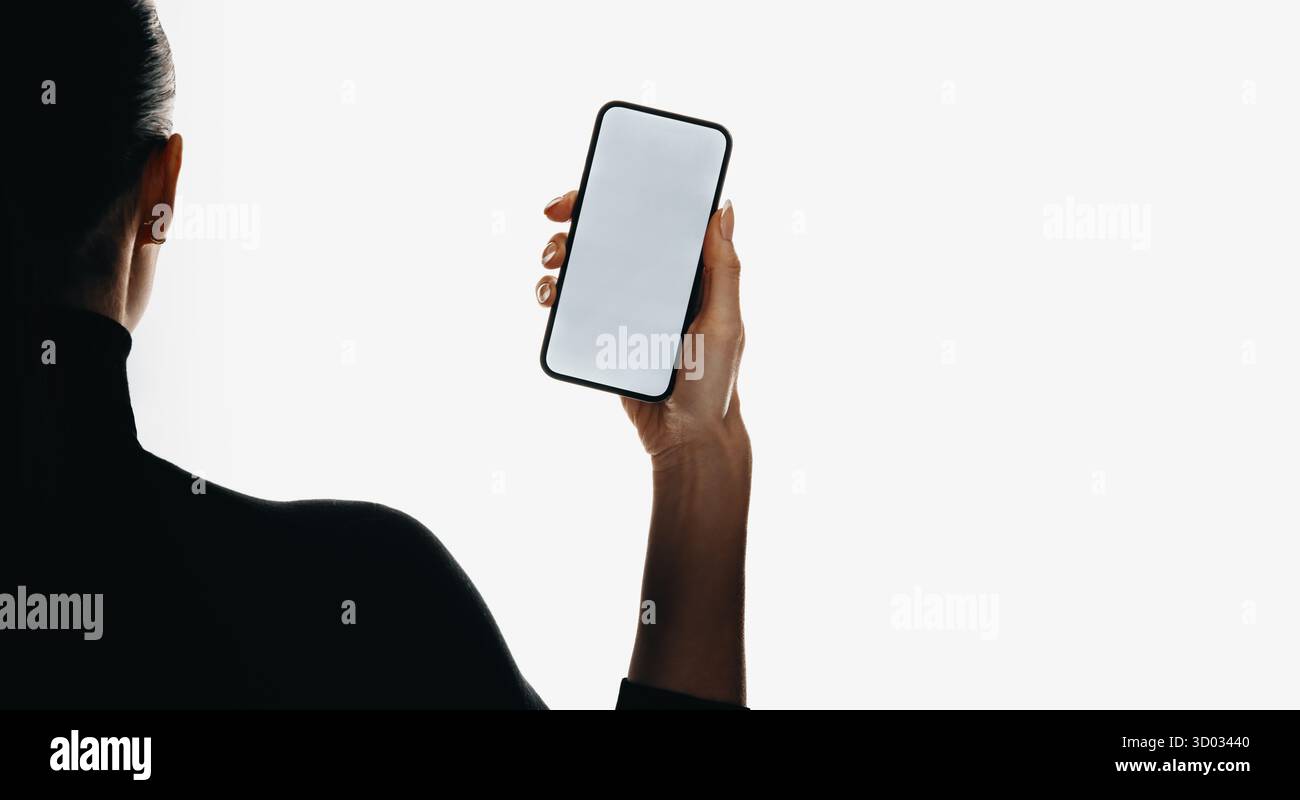 Eine Person von hinten, die ein Smartphone mit einem weißen Bildschirm hält, perfekt für Design-Showcases. Stockfoto
