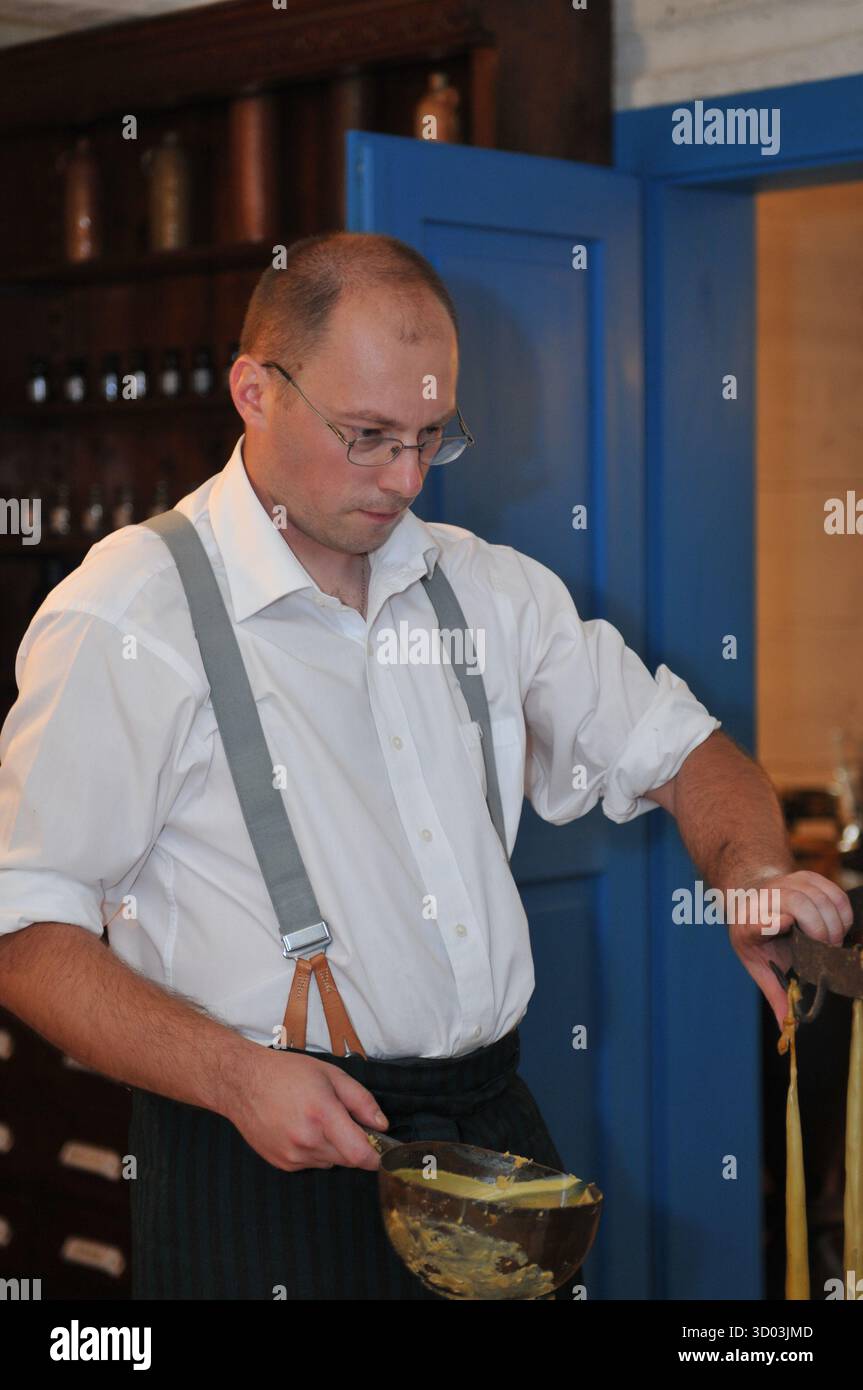 Apotheker demonstriert die traditionelle Herstellung von Wachskerzen im Museum of Folk Architecture in Sanok, Polen. Stockfoto