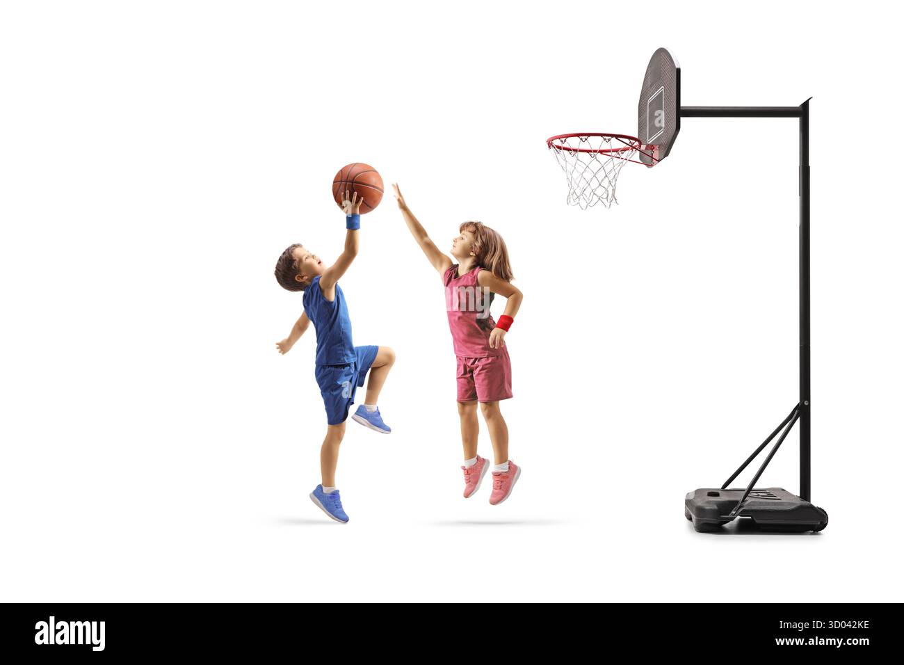 Junge und Mädchen spielen Basketball und springen unter dem Netz isoliert auf weißem Hintergrund Stockfoto