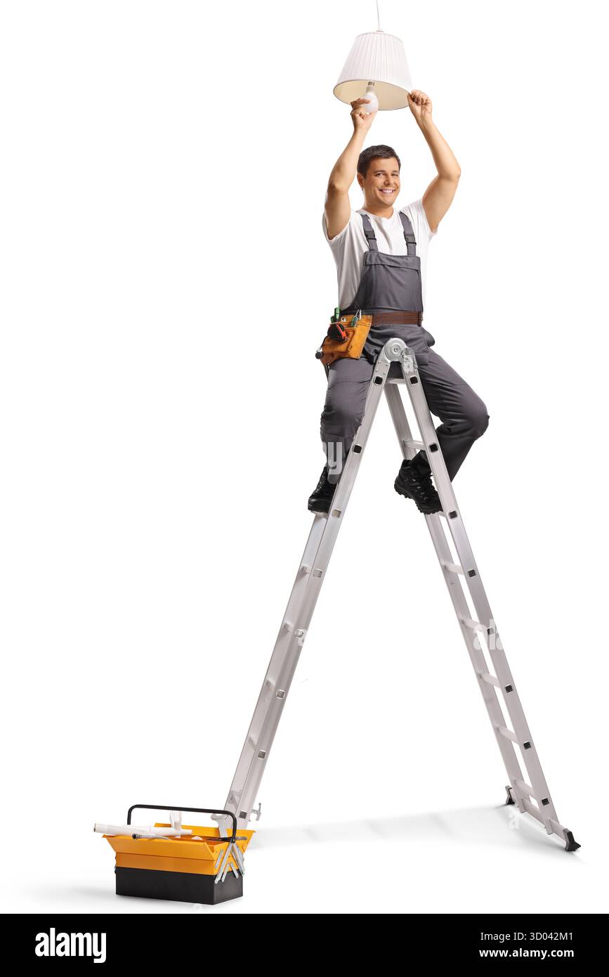 Arbeiter in Uniform, der auf einer Teleskopleiter sitzt und eine Glühbirne auf weißem Hintergrund wechselt Stockfoto