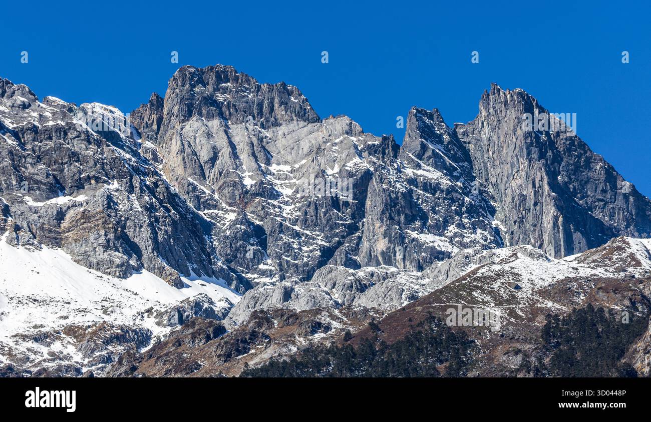 Schneebedeckte felsige Gipfel der Jade Dragon Snow Mountains in der Provinz Yunnan, Stadt Lijiang, China. Alpine Landschaft und zerklüftete geologische Formationen. Stockfoto