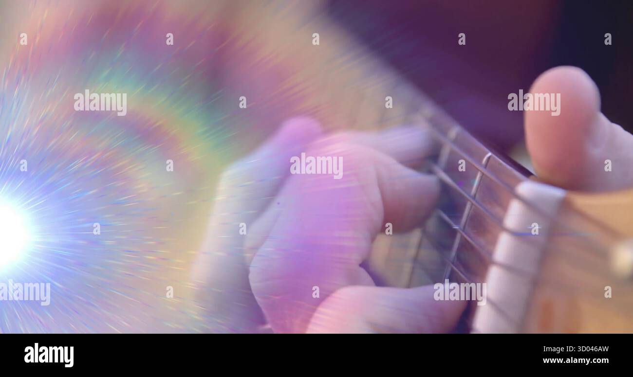 Die linke Hand des Musikers drückt Akkorde auf akustischen Gitarrensaiten im Studio mit Regenbogenfleck Stockfoto