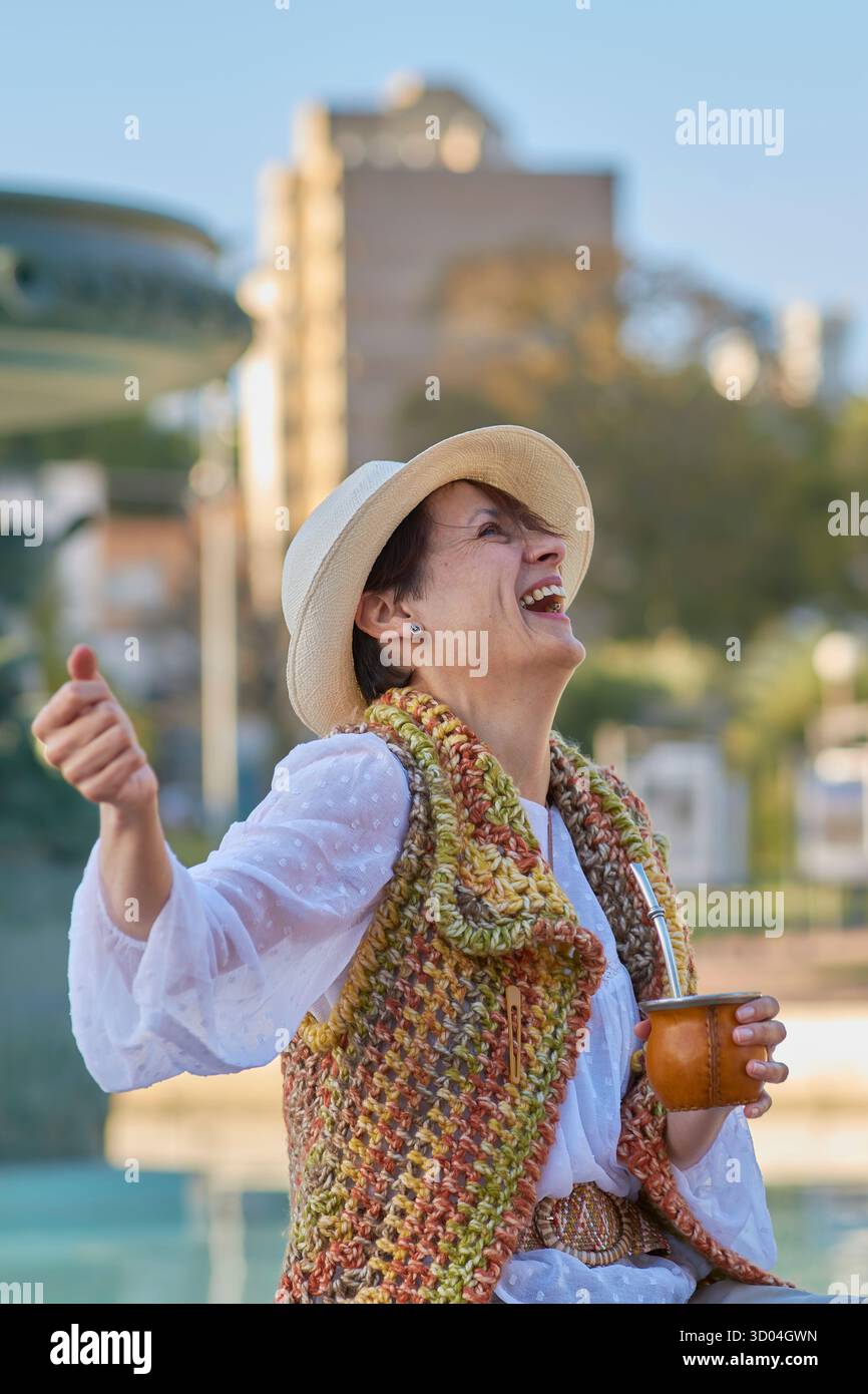 Die Frau lacht mit dem Partner in der Hand in einer natürlichen städtischen Umgebung. Eine lebendige Szene, die Freude, kulturelle Identität und emotionale Verbindung im lateinischen Ameri zelebriert Stockfoto