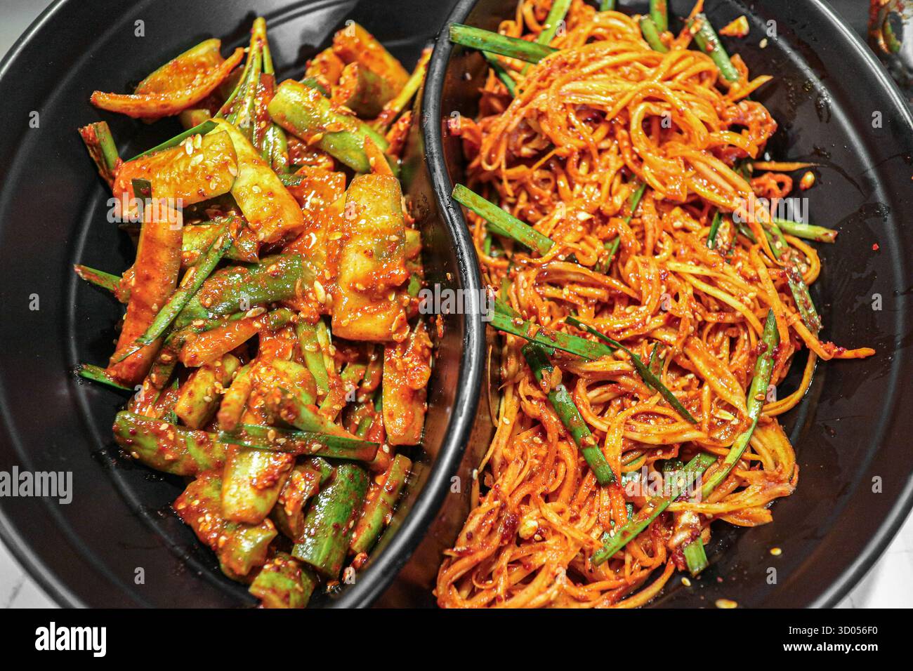 Verschiedene scharfe koreanische Banchan (Gurken- und KarottenKimchi) in einer Schüssel. Grundlegende K-Food Beilagen, lebendige und authentische Küche. Stockfoto