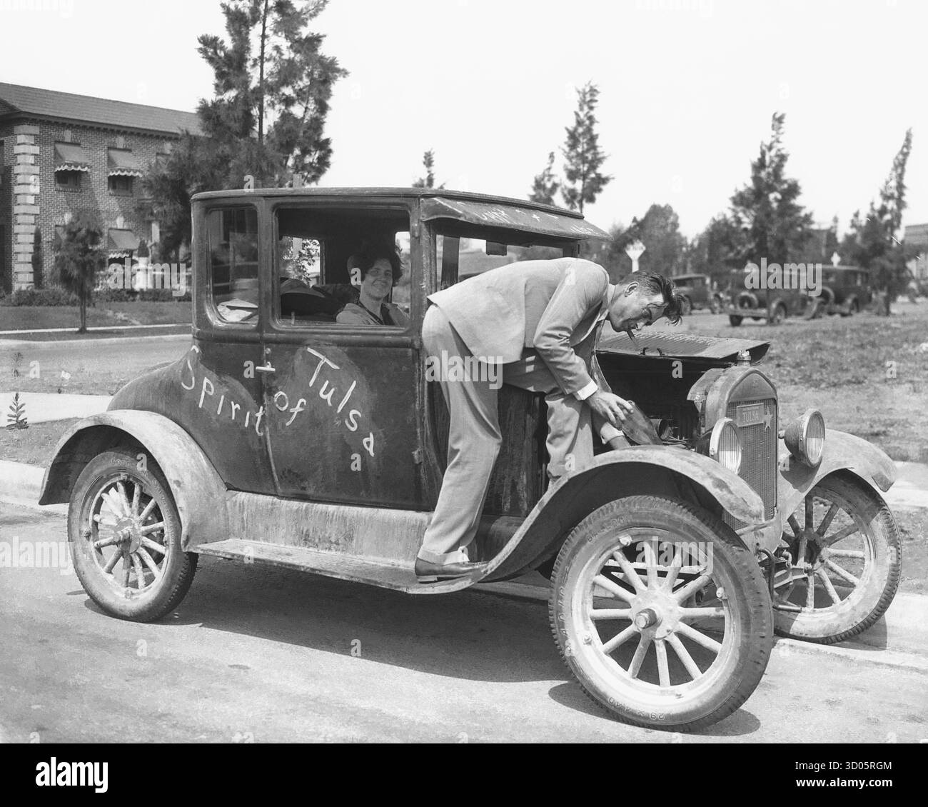 Ein Model T Auto mit einem Mann, der das Auto repariert Stockfoto