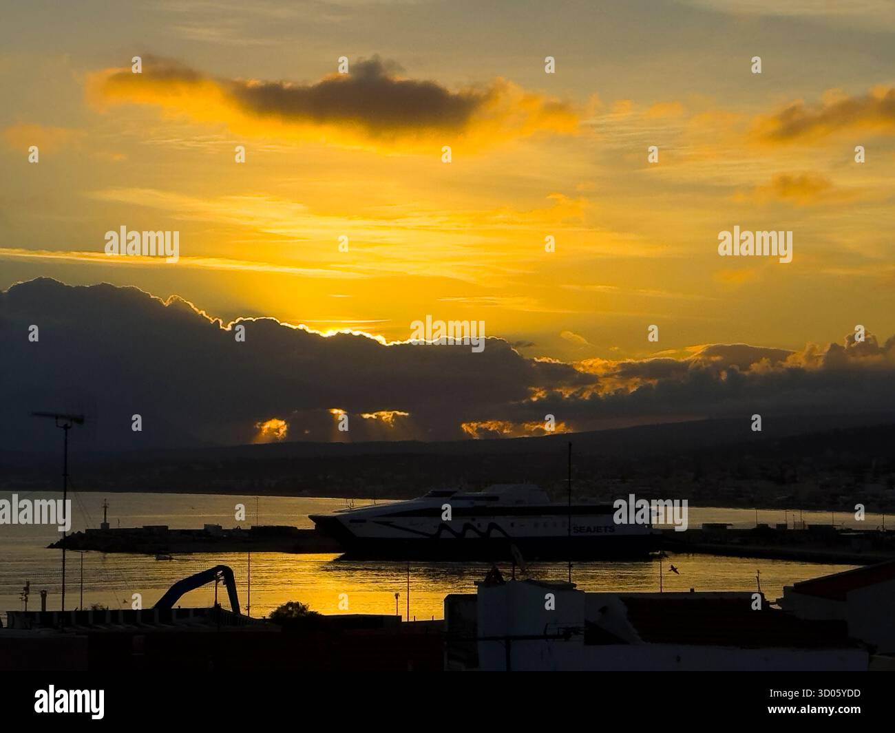 Sonnenuntergang über dem Hafen von Rethymno und der Seajet-Fähre - Kreta, Griechenland Stockfoto
