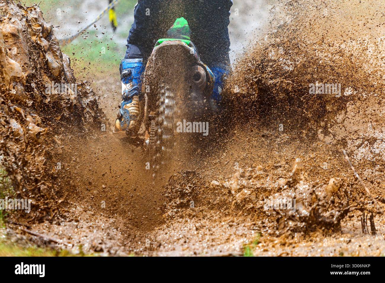enduro fährt mit viel Spritzer durch den Schlamm, Fahrer spritzen Schlamm auf nassem und schlammigem Gelände, Motocross-Racer in nassem und schlammigem Gelände über die dri Stockfoto