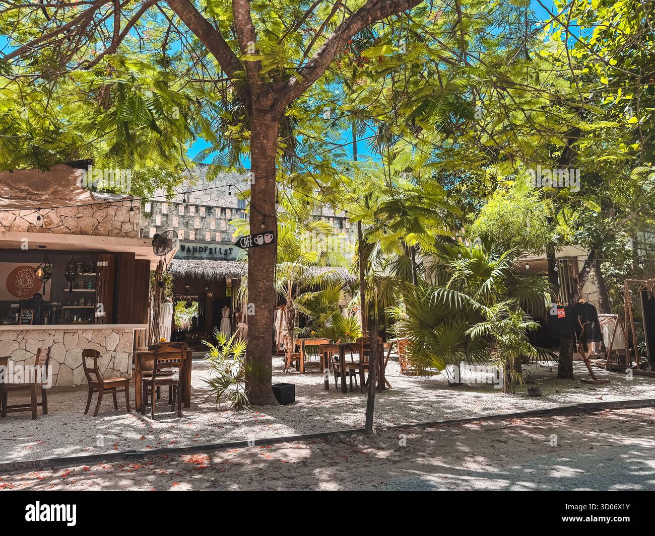 Tulum, Quintana Roo, Mexiko, kleines Café im Freien mit ein paar Tischen und Stühlen. Die Tabellen sind leer. Das Café ist von Bäumen umgeben und hat eine Terrasse Stockfoto