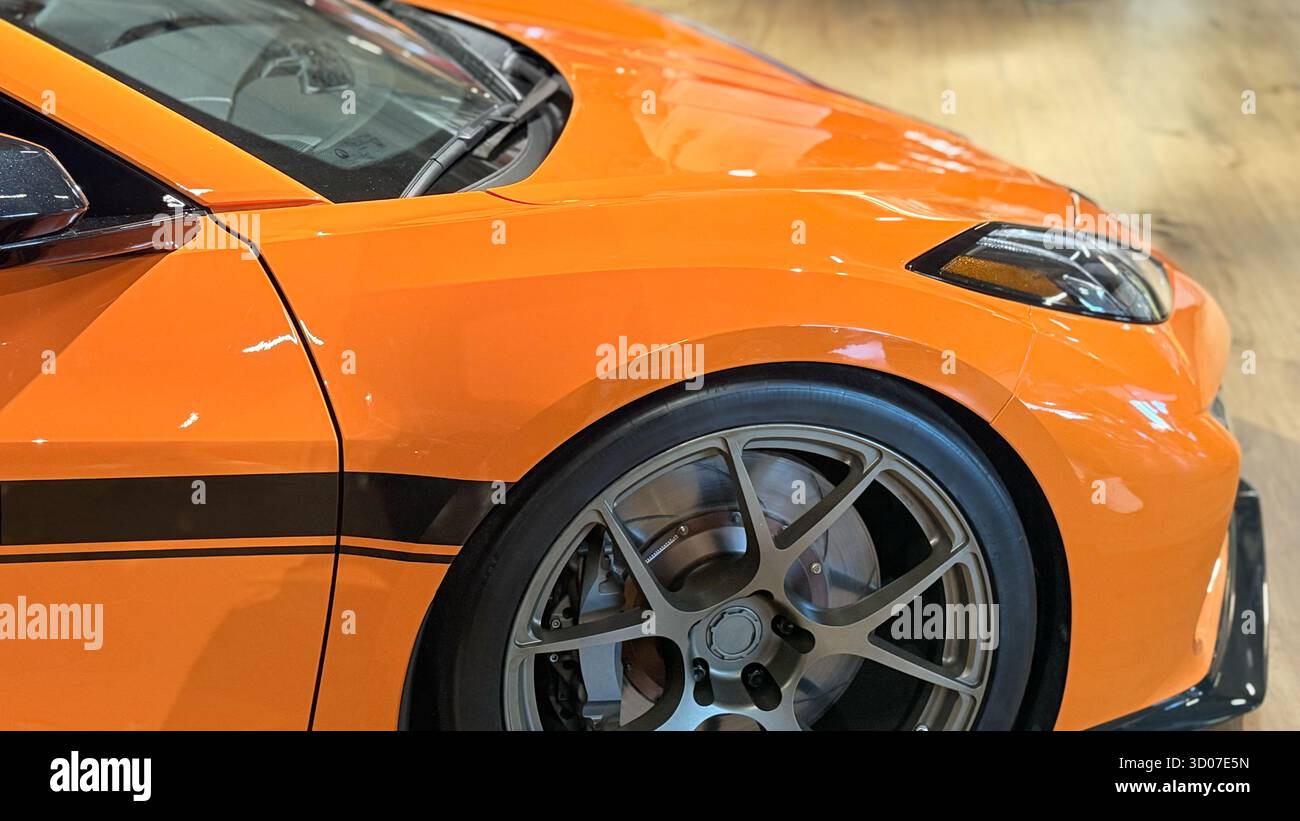 Orangefarbener Sportwagen Mit Leichtmetallfelgen, Performance Vehicle Detail, Modernes Automobildesign, Street Racing Car Karosserie, Hochwertiger Tuning Style - Smartphone-aufgenommenes Stockfoto