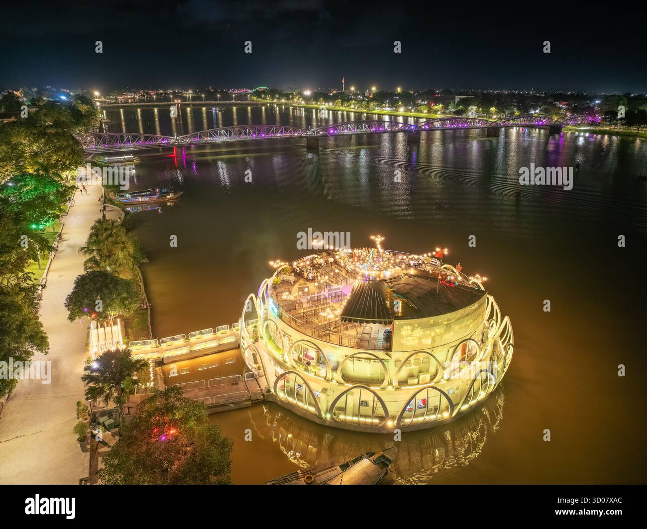 Hue City, Vietnam - 15. Oktober 2025: Panoramablick auf die Truong Tien Bridge in Hue City bei Nacht. Die Brücke ist überall beleuchtet und die Reflexion ist verschwommen. T Stockfoto Hue City, Vietnam - 15. Oktober 2025: Panoramablick auf die Truong Tien Bridge in Hue City bei Nacht. Die Brücke ist überall beleuchtet und die Reflexion ist verschwommen. T Stockfoto