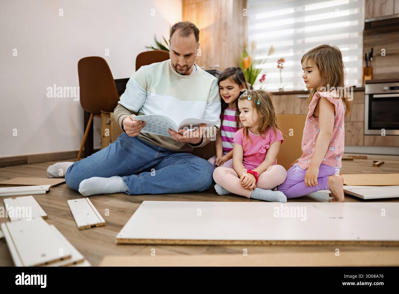 Familienverbindung beim Zusammenbauen von Möbeln an einem sonnigen Nachmittag Stockfoto