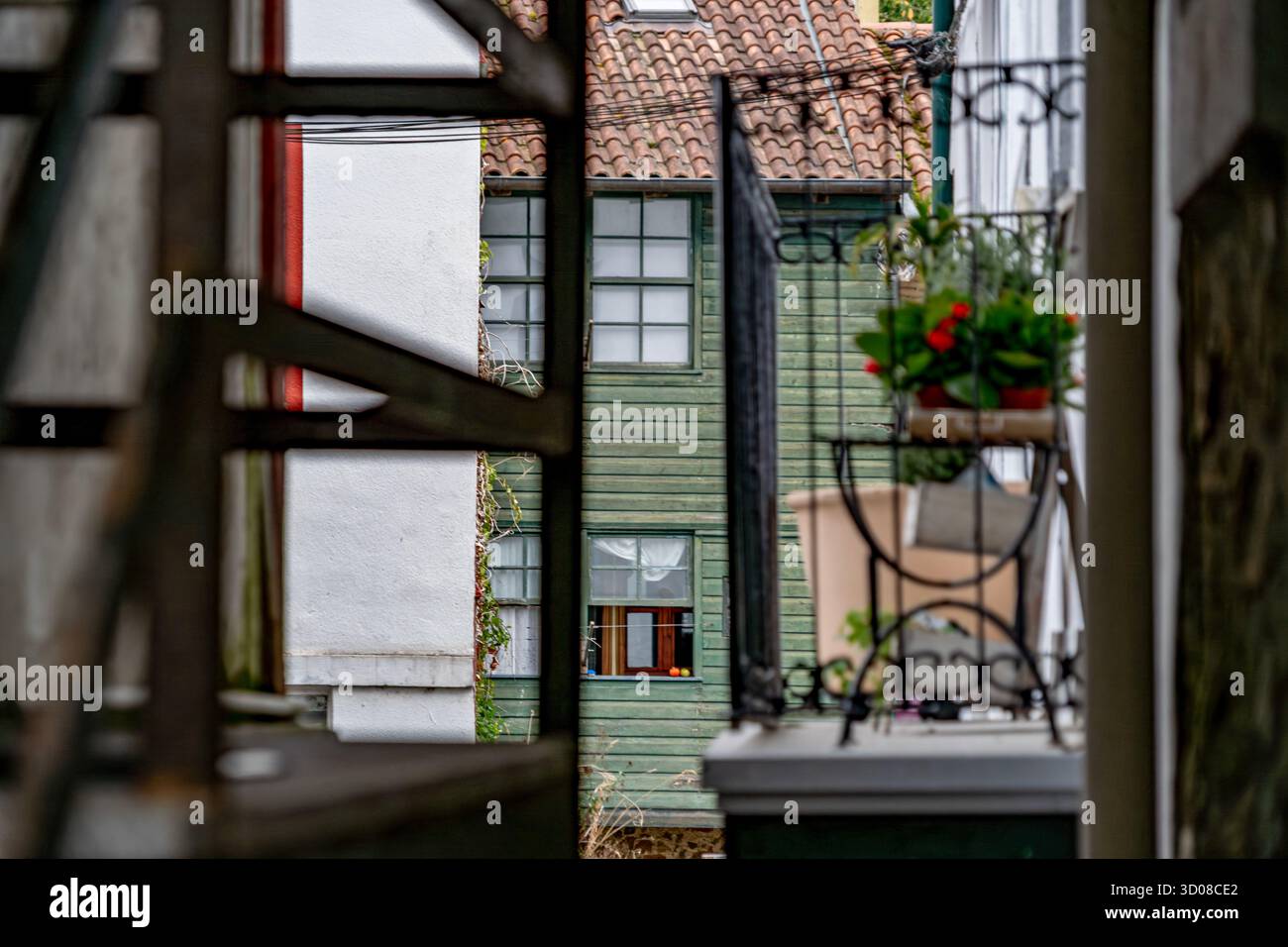 Mehrschichtige Holzhäuser mit Terrakottadächern, Blick durch eiserne Balkongeländer, traditionelle Küstenarchitektur, EA Village, Baskenland Stockfoto