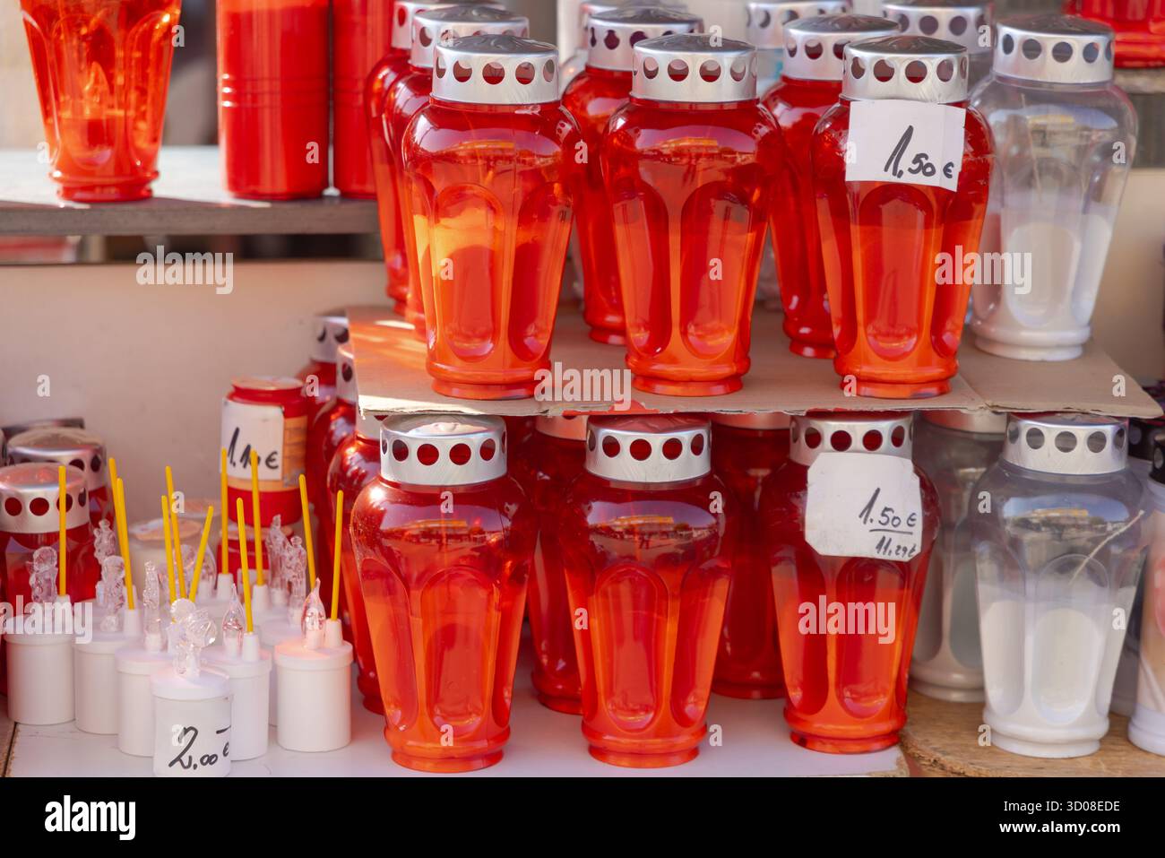 Neue rote Kerzenhalter und LED-Lampen aus Kunststoff im Regal Stockfoto